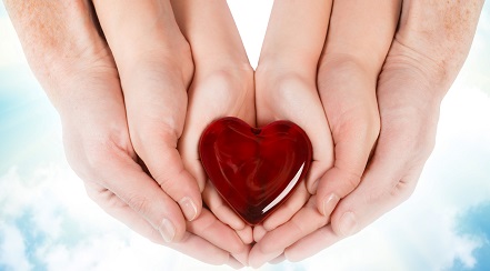 Image of three hands holding a heart shaped object