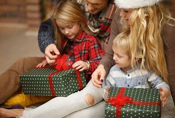 Image of children opening gifts with parents