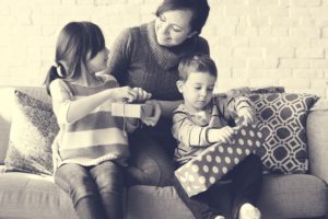 Image of children opening gifts with mom